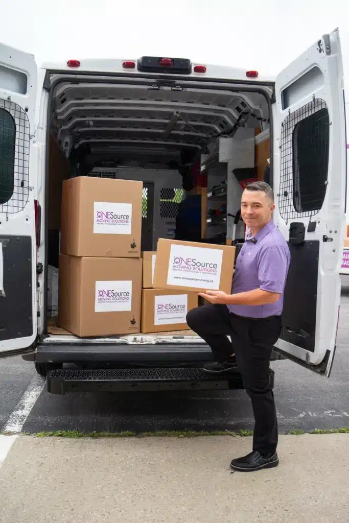 Rob from ONESource Moving Solutions loading boxes into the company van during a senior downsizing project in Calgary’s Tuscany community.
