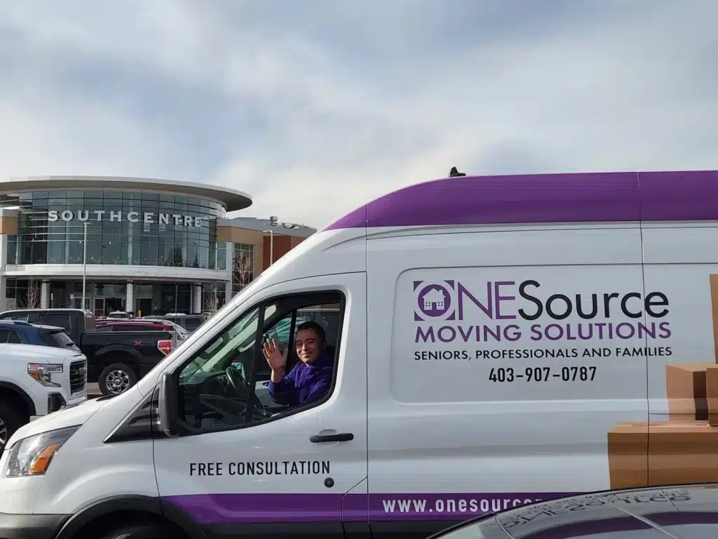 Rob from ONESource Moving Solutions waving from the company van at Southcentre Mall in Southeast Calgary during a senior downsizing visit.